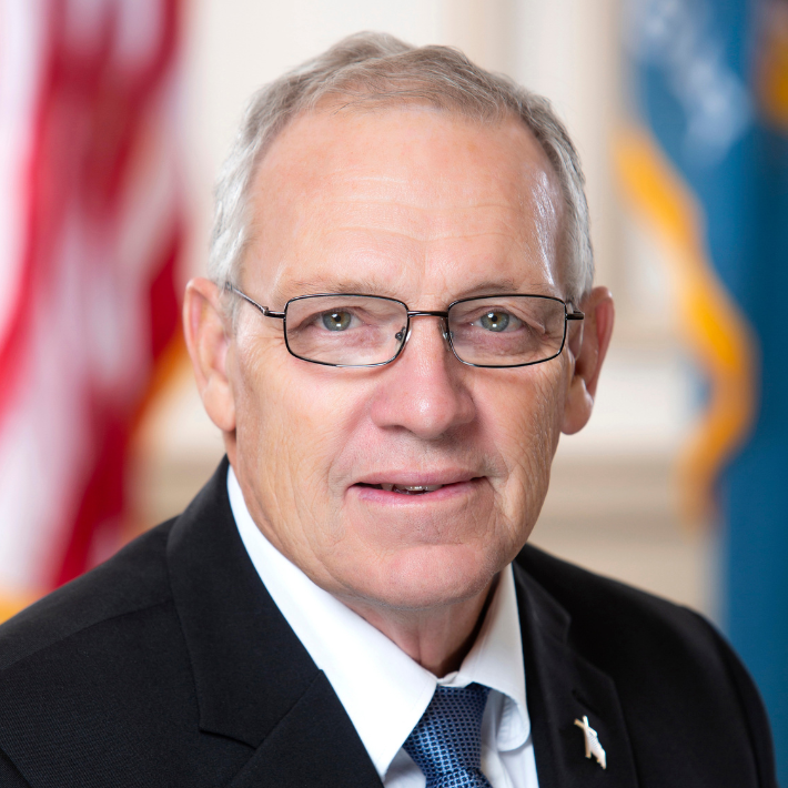 Portrait of Representative Rich Collins with the American and Delaware flags in the background