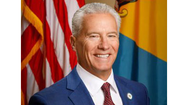 Rep. Yearick smiling in front of the US and Delaware State Flags.