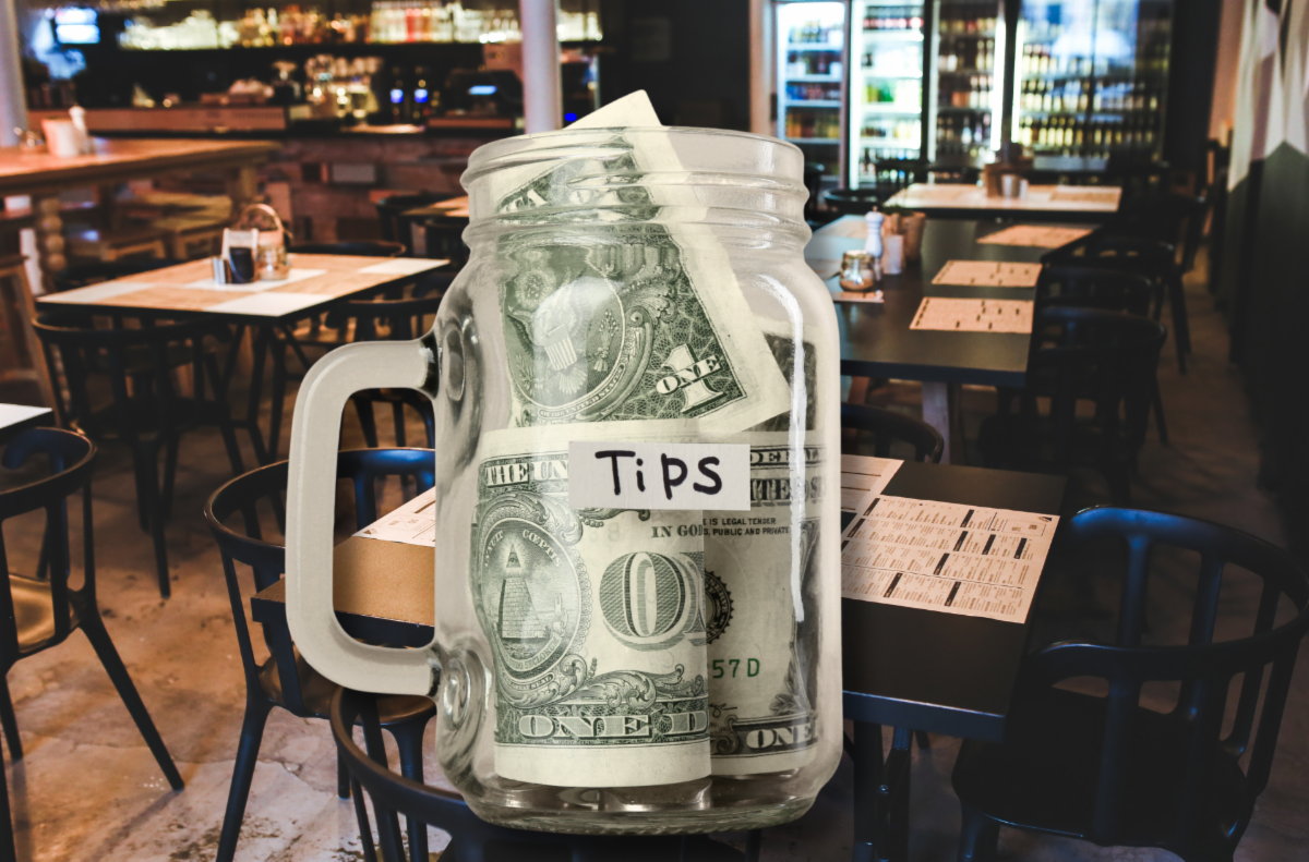Tips in a clear mason jar drinking glass on a restaurant eating area background highlighting tipped worker tax relief.